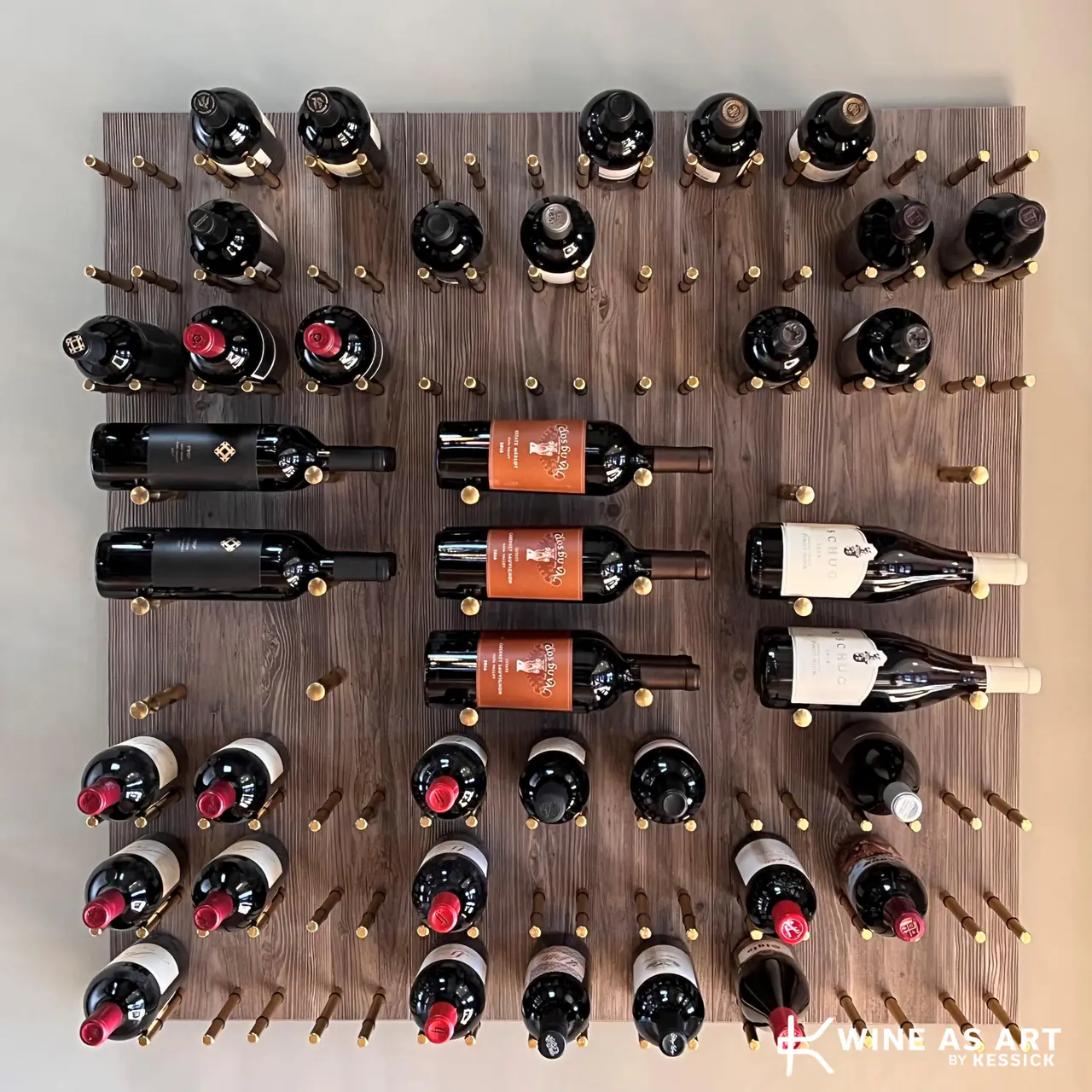Bottles on brass pegs across a timber panel, some face-out, most neck-out.