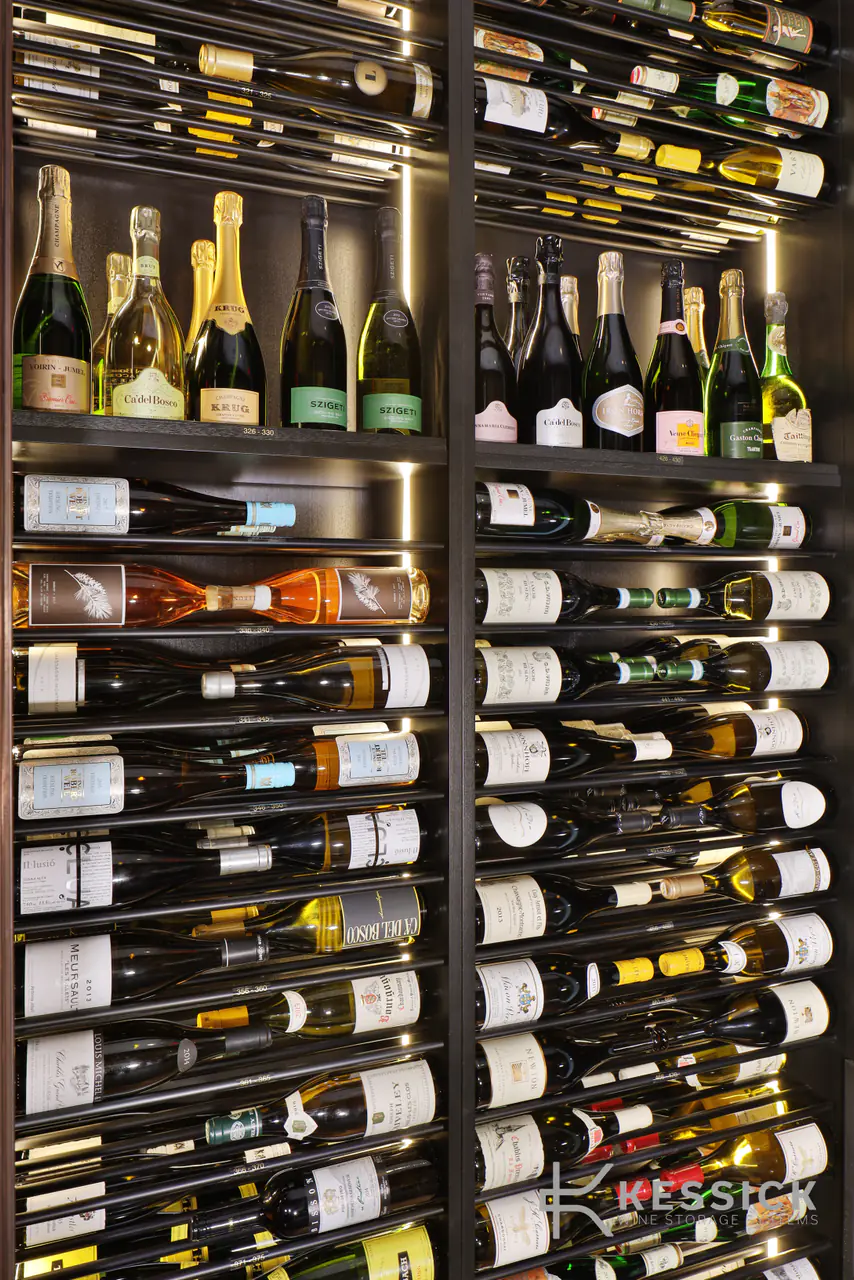 A tall dark rack of wine on slim rods, champagne on the shelf above.