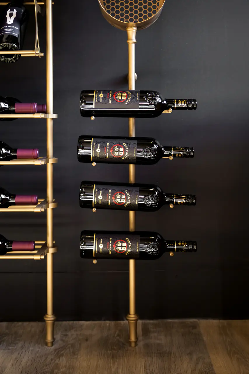 Bottles held on a single brass upright, labels forward.