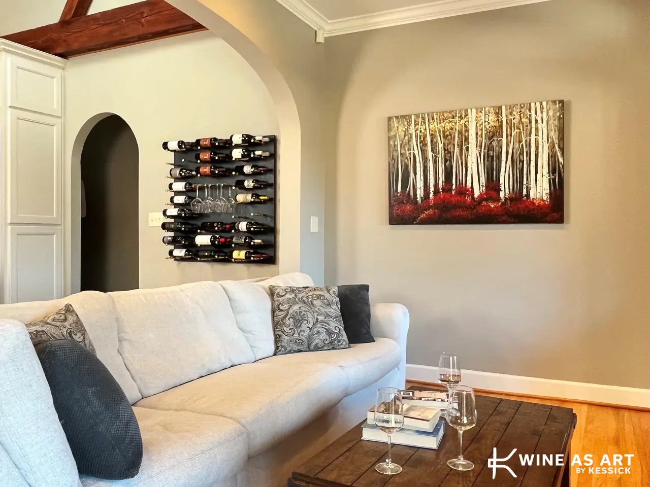 A living room with a small wine wall and hanging glasses beside the sofa.