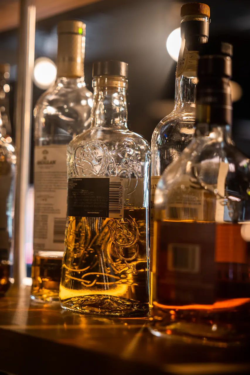Whisky decanters on a bar top, close up.