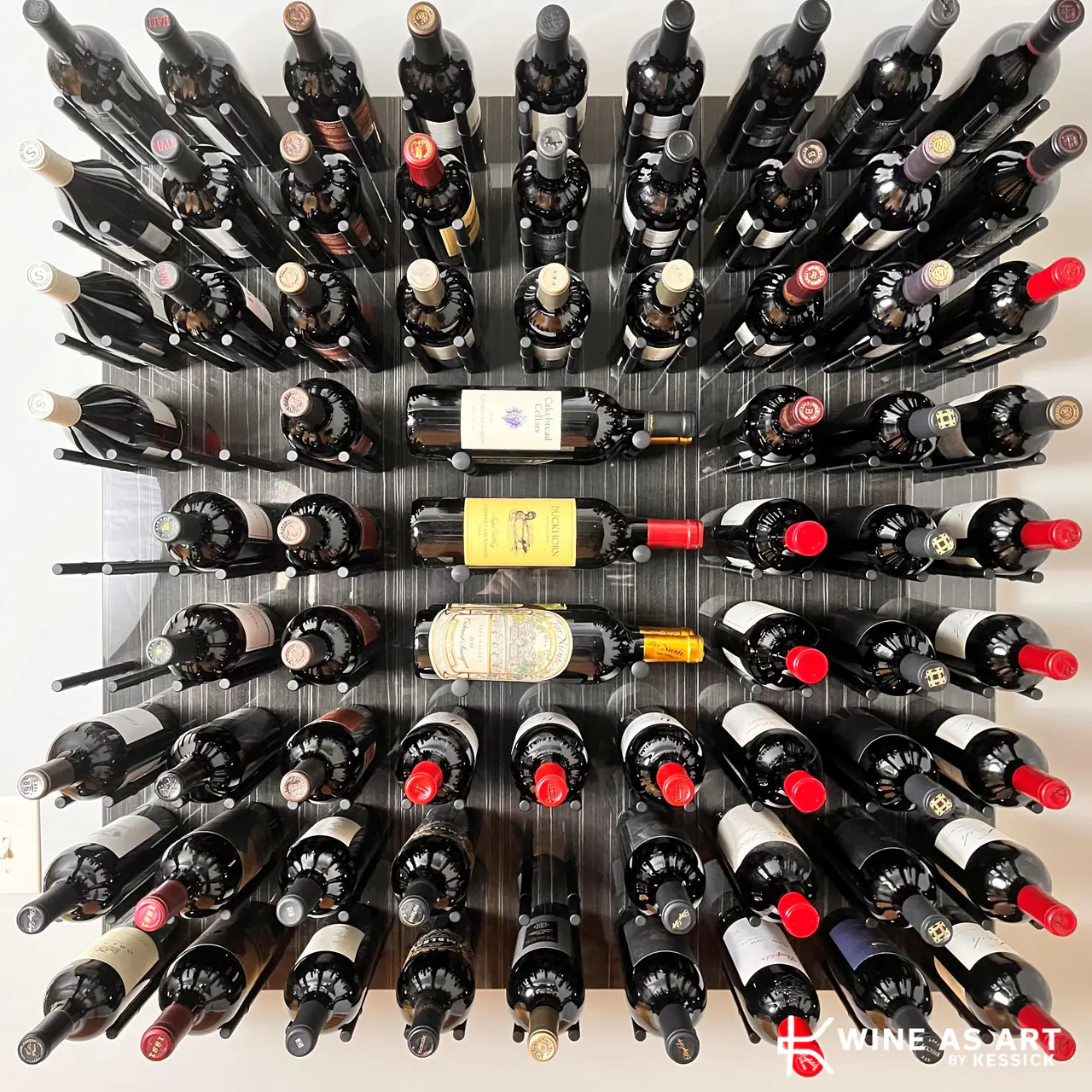 A dark panel of wine on pegs, bottles fanned in a radial pattern.