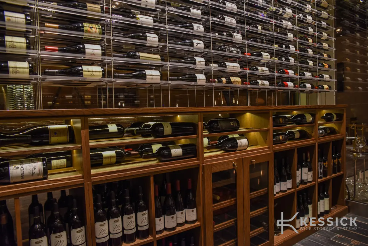 Timber cabinets with bottles laid on rods above, lit along the counter.