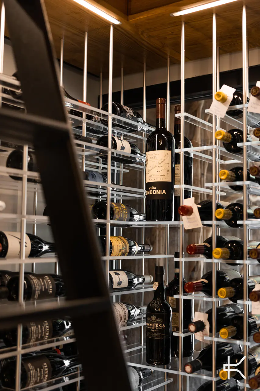 A library ladder against white steel wine racks.
