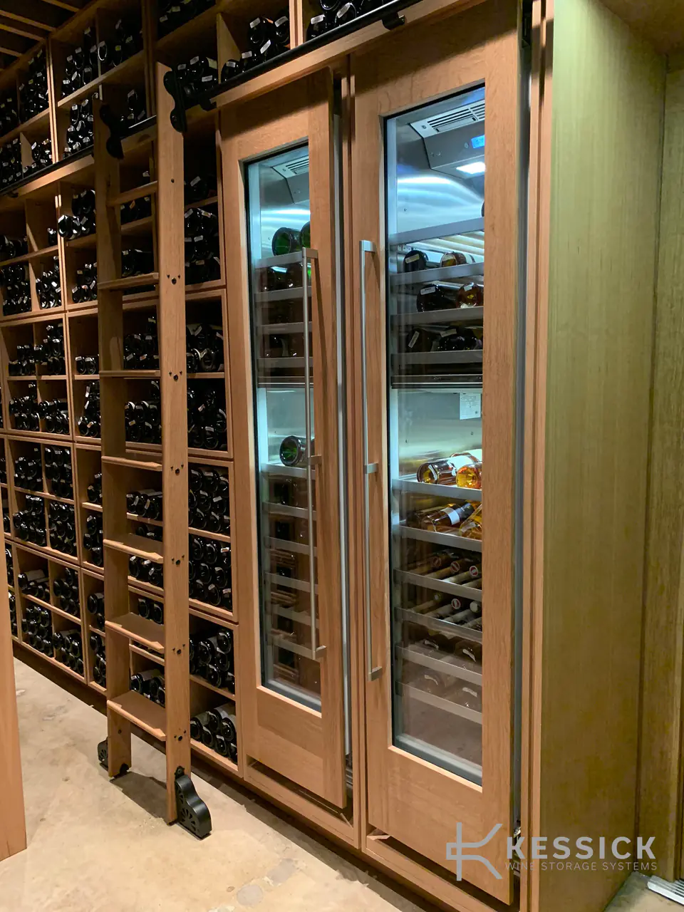 Tall glass doors in a timber wine wall, a rolling ladder beside them.