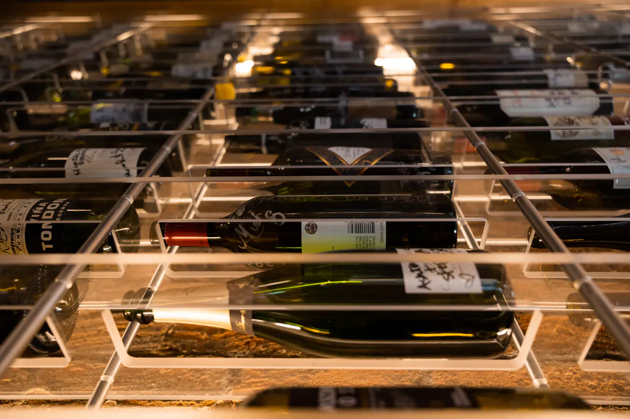 Bottles resting in white steel cradles, close up.