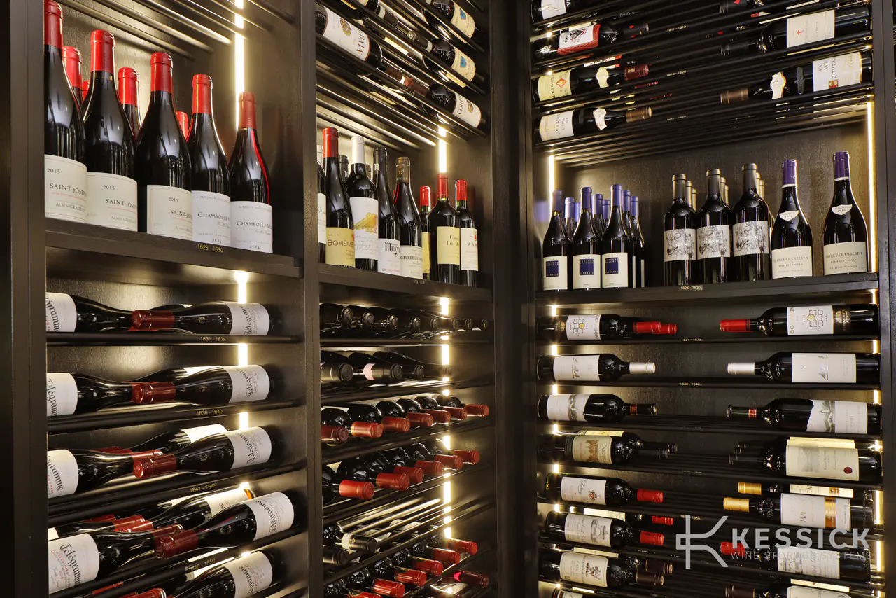 Rows of red and white wine on dark rods, lit along the uprights.