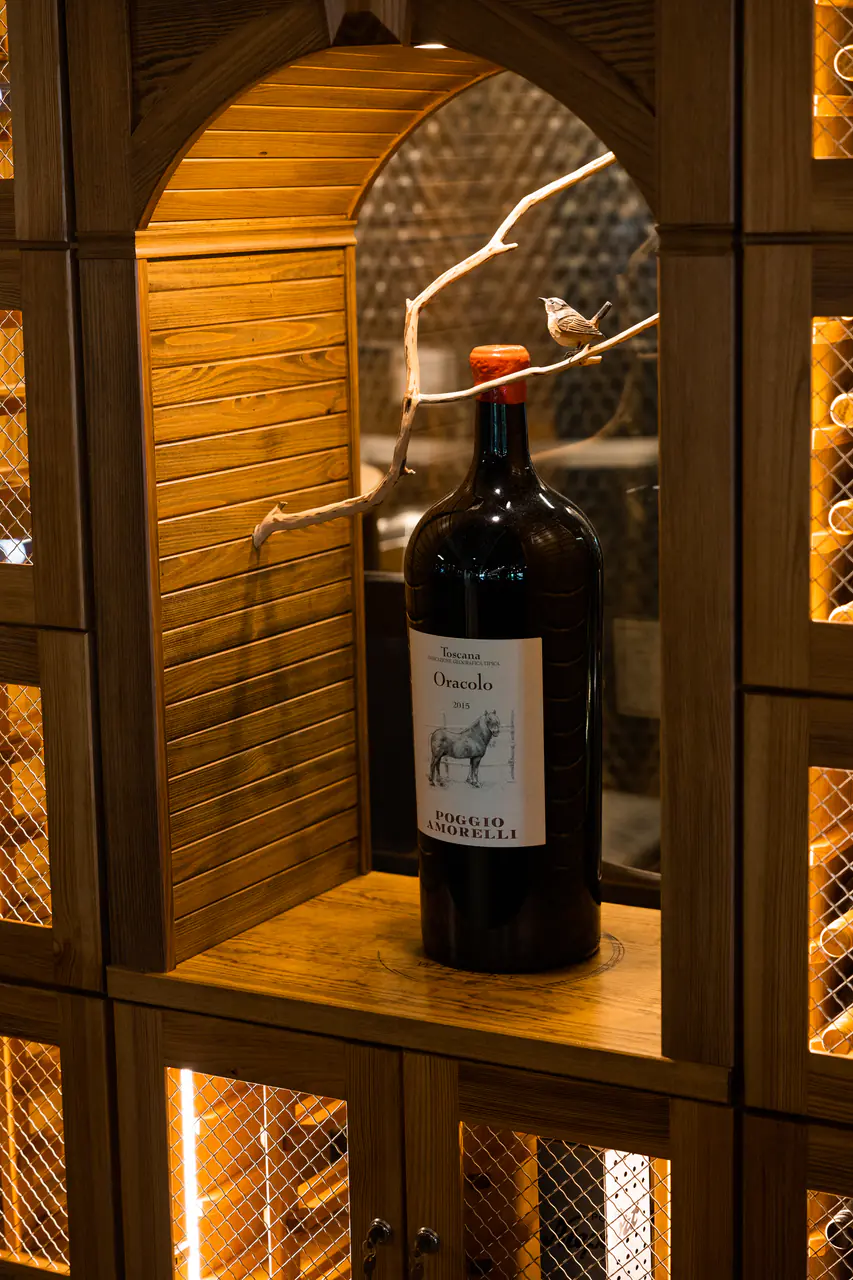A large-format bottle in an arched timber niche, lockers on either side.