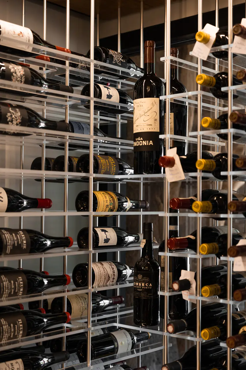 Bottles in white steel racks, some standing, some lying.